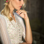 Blonde Frau in geblümtem Dirndl und Blumen im Haar