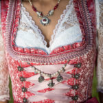 Korallfarbenes Dirndl mit Schmuck